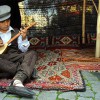 A child playing saz in a tent